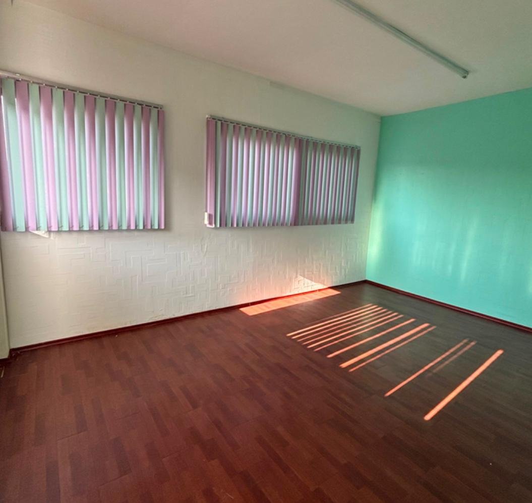 Consultorio con piso laminado y ventanas amplias